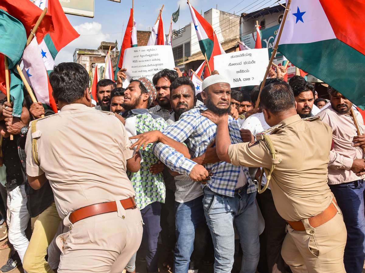 Police officers restrain protesters during a public demonstration with flags and signs. Police officers restrain protesters during a public demonstration with flags and signs.