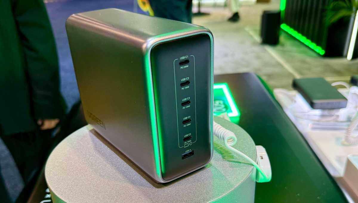 A multi-port USB hub displays on a stand at a tech exhibition with green lighting. A multi-port USB hub displays on a stand at a tech exhibition with green lighting.