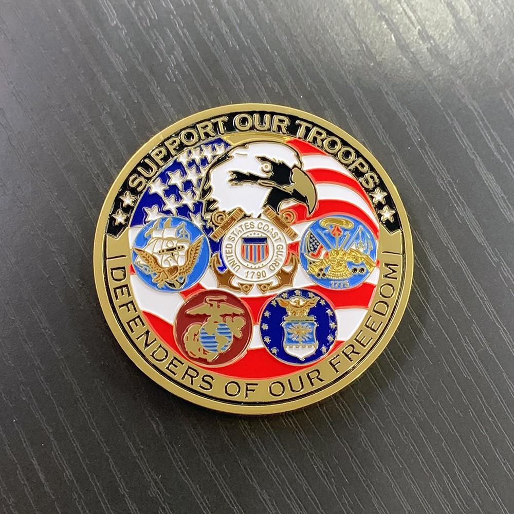 A circular "Support Our Troops" pin with US military insignias rests on a dark wood surface.