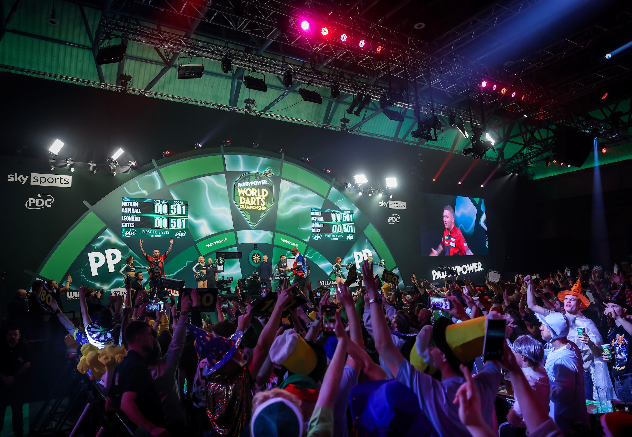 Paddy Power World Darts Championship spectators cheer at indoor arena during match.