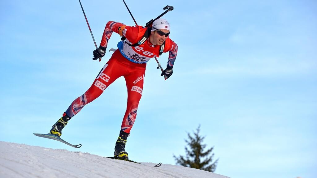 A cross-country skier in red gear skis downhill on snow under a clear blue sky. A cross-country skier in red gear skis downhill on snow under a clear blue sky.