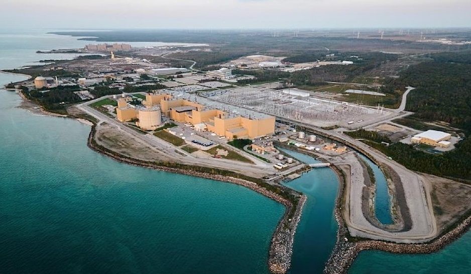 Nuclear power plant complex sits on a coastal shoreline with surrounding industrial structures. Nuclear power plant complex sits on a coastal shoreline with surrounding industrial structures.