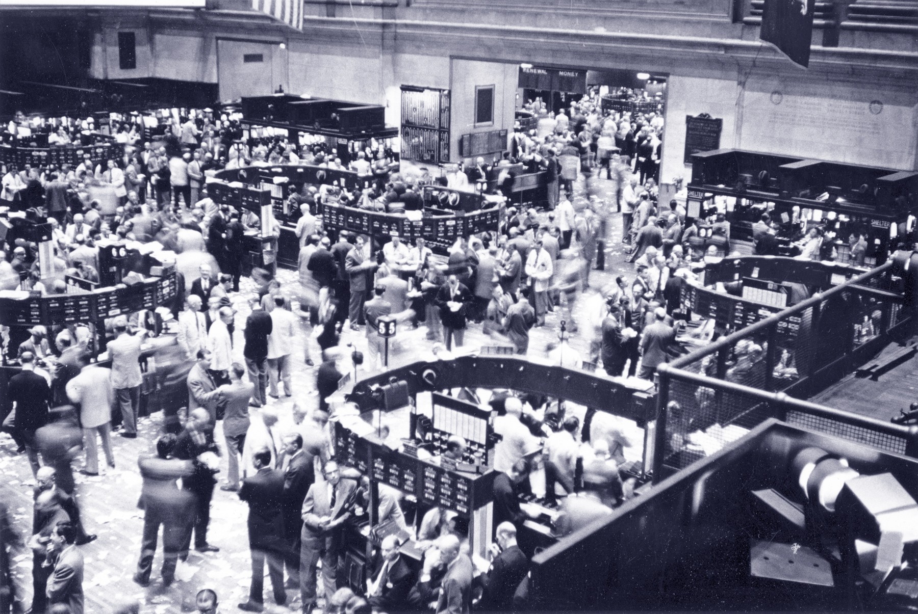 Traders interact on a crowded stock exchange trading floor at desks and counters. Traders interact on a crowded stock exchange trading floor at desks and counters.