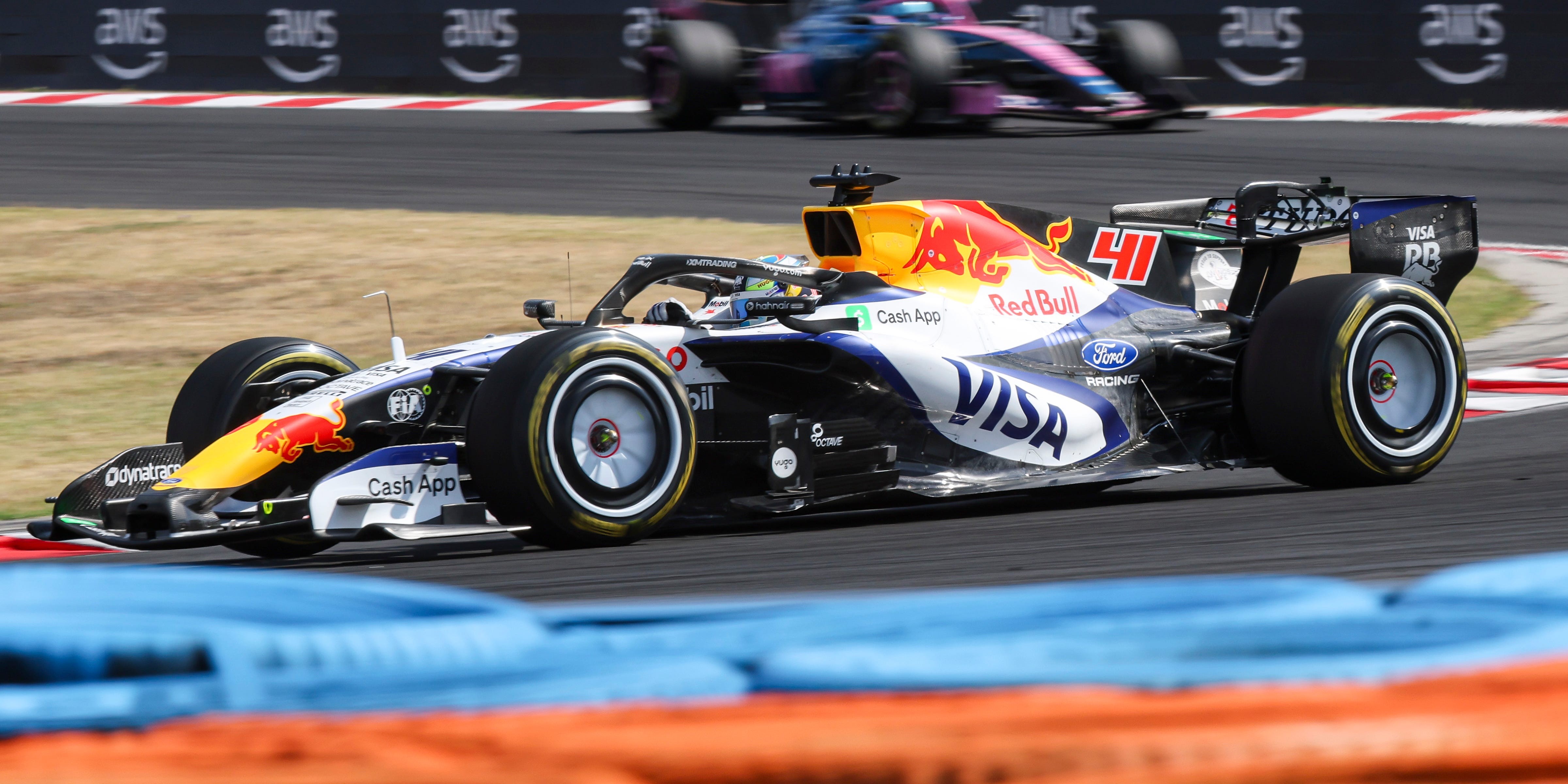 A Red Bull Racing Formula 1 car number 41 races on a racetrack with other cars visible.