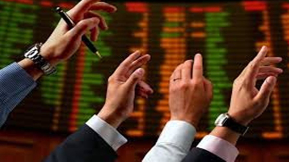 Three businesspeople's hands point at a digital stock ticker screen showing green and red numbers. Three businesspeople's hands point at a digital stock ticker screen showing green and red numbers.