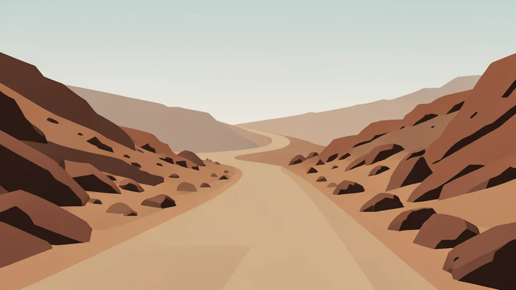A dusty, unpaved road winding through arid, rocky terrain under a hazy sky