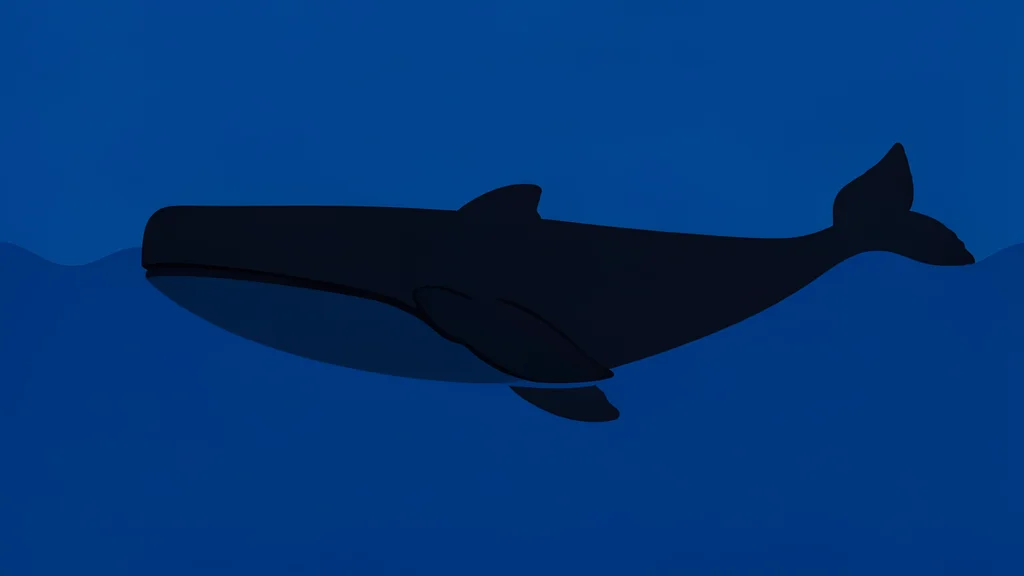 A large dark whale swimming through deep blue water