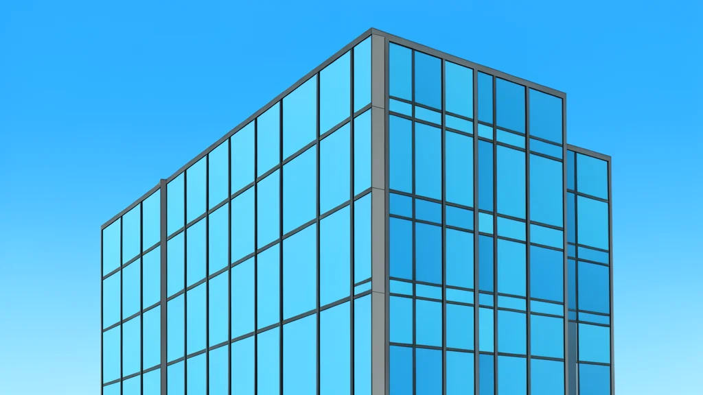 A modern glass office building facade reflecting a clear blue sky