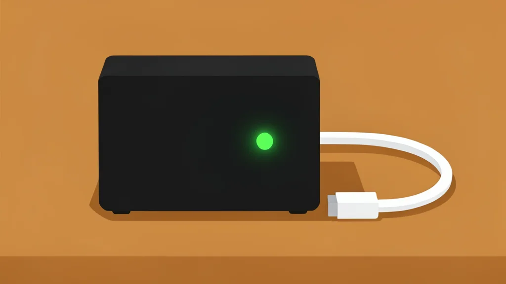 A small black rectangular computer box with a single green light on a wooden desk next to a white cable.