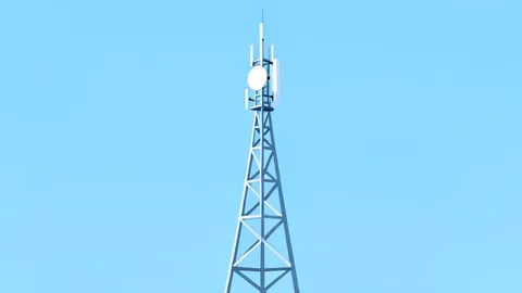 A modern telecommunications antenna tower standing against a clear sky
