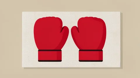 A pair of red boxing gloves resting on a canvas mat