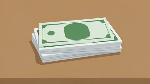A stack of banknotes and a single foreign currency bill resting on a wooden desk.