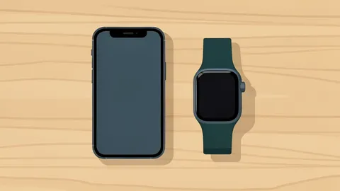 A smartphone and a smartwatch resting on a wooden desk