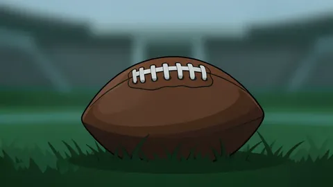 A football resting on the green grass of a stadium field