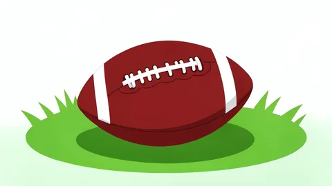 An American football resting on green grass