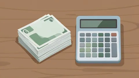 A stack of paper currency and a calculator on a wooden desk
