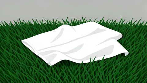 A worn leather football resting on green artificial turf
