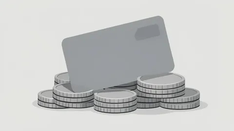 A credit card resting on a stack of physical coins