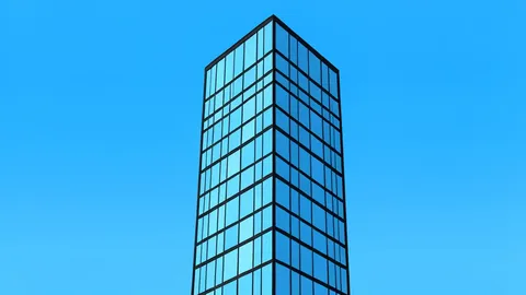 A modern glass skyscraper reflecting a clear blue sky
