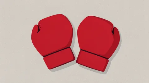 A pair of red boxing gloves resting on a textured canvas floor