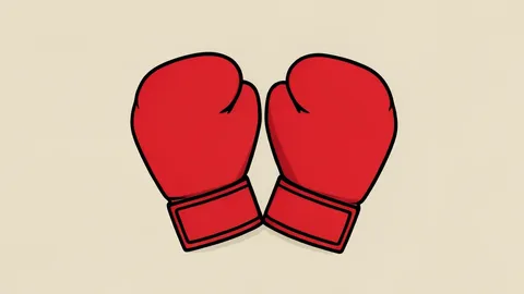 A pair of red boxing gloves resting on a canvas floor