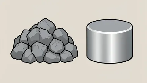 A raw pile of grey mineral ore next to a polished, cylindrical metallic magnet