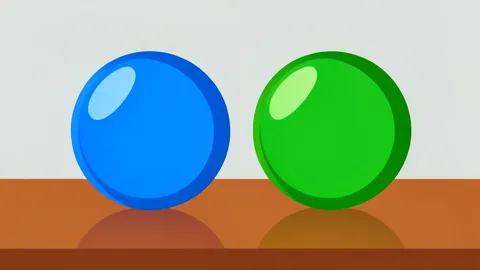 Two glass spheres, one blue and one green, resting on a polished wooden desk.