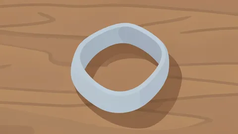 A slim fitness tracker with a soft band resting on a wooden surface