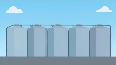 A row of industrial oil storage tanks under a clear sky