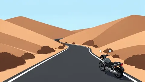 A paved rural road winding through arid hills with a single motorcycle parked on the shoulder.