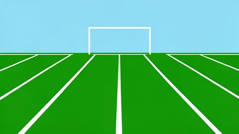 A wide shot of a green football field with white yard lines and goalposts at the end zone.