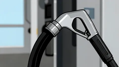 A fuel pump nozzle resting on a concrete island at a gas station