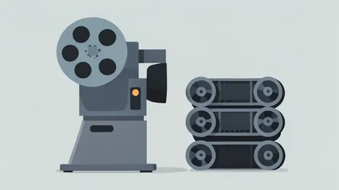 A vintage film projector and a stack of 35mm film reels