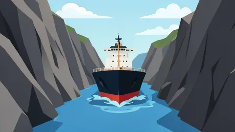 A large oil tanker navigating through a narrow strait between rocky cliffs