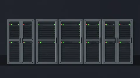 A row of industrial server racks with blinking status lights in a dark room