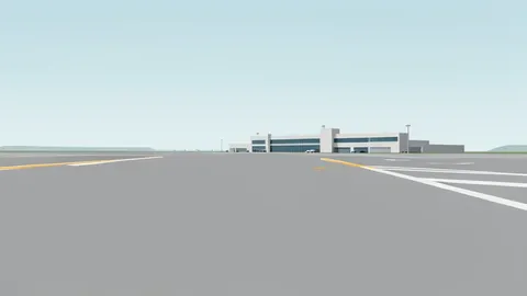A wide expanse of grey airport tarmac stretching toward a distant terminal building under a hazy sky