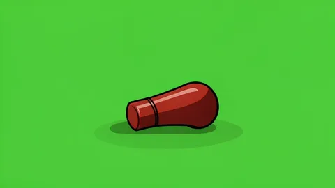 A soccer referee's whistle resting on a green grass pitch