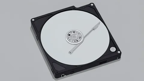 A row of hard drive bays inside a server rack with a small digital thermometer resting on the shelf
