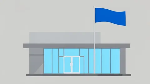 A modern bank branch facade with a glass entrance and a flagpole flying a plain blue flag