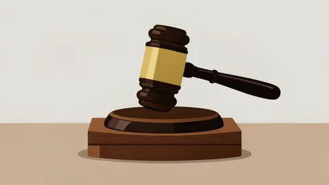A gavel resting on a wooden sound block in a courtroom