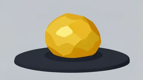 A rough, unrefined nugget of gold resting on a dark stone surface