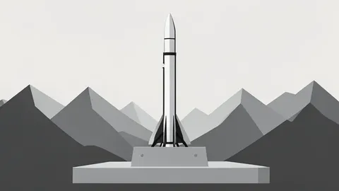 A vertical ballistic missile on a concrete pad in a mountainous landscape