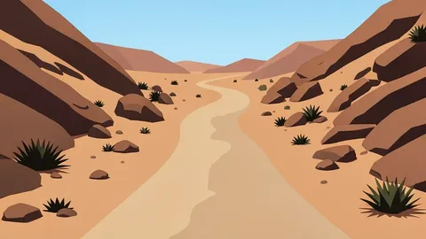 A dusty, unpaved road winding through arid, rocky terrain with sparse vegetation