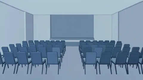 A large conference hall with rows of empty chairs and a stage