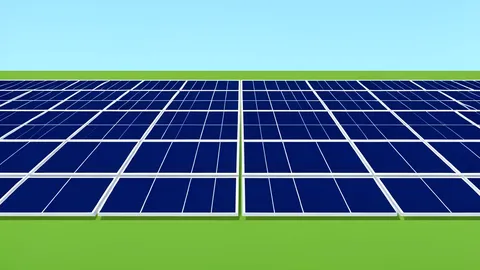 A field of large, dark blue photovoltaic solar panels arranged in rows under a clear sky
