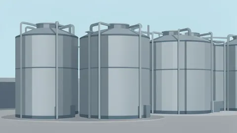A row of large, cylindrical steel storage tanks standing in an industrial facility