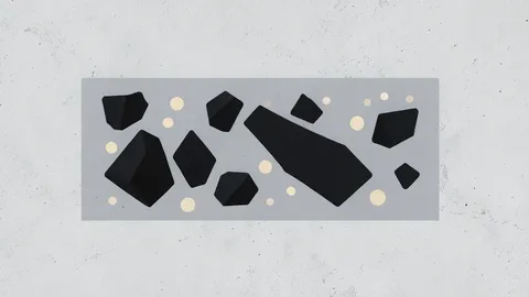 A cross-section of a porous concrete block showing embedded dark charcoal-like particles and light mineral grains