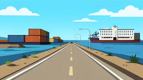 A dusty coastal road leading to a port city with shipping containers and a hospital building in the distance