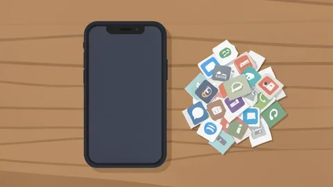 A modern smartphone lying on a wooden desk next to a small pile of discarded paper app icons