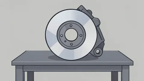A polished metal automotive brake rotor and caliper assembly resting on a workshop bench.